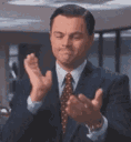 Leonardo DiCaprio in a suit performing a slow, sarcastic clap.