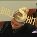 A woman looking down in a courtroom with the word BULLSHIT overlaid in large gold letters.